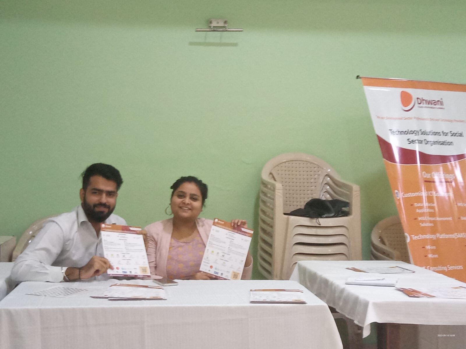 Dhwani staff working alongside a partner organisation's team at their venue